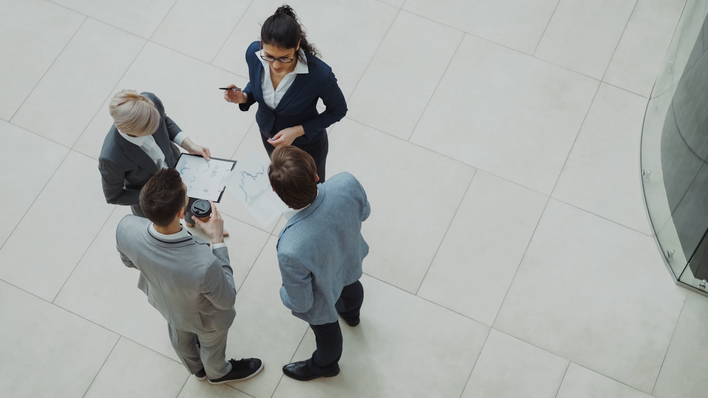 Profesionales de negocios colaborando sobre gráficos en una oficina moderna.